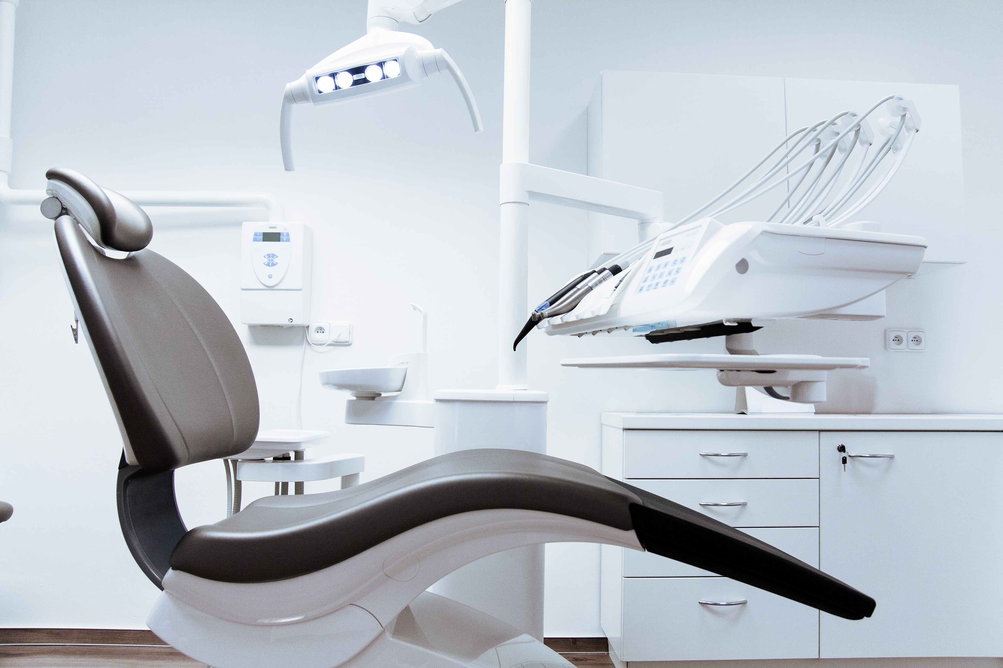 a dental office with reclining chair and other equipment