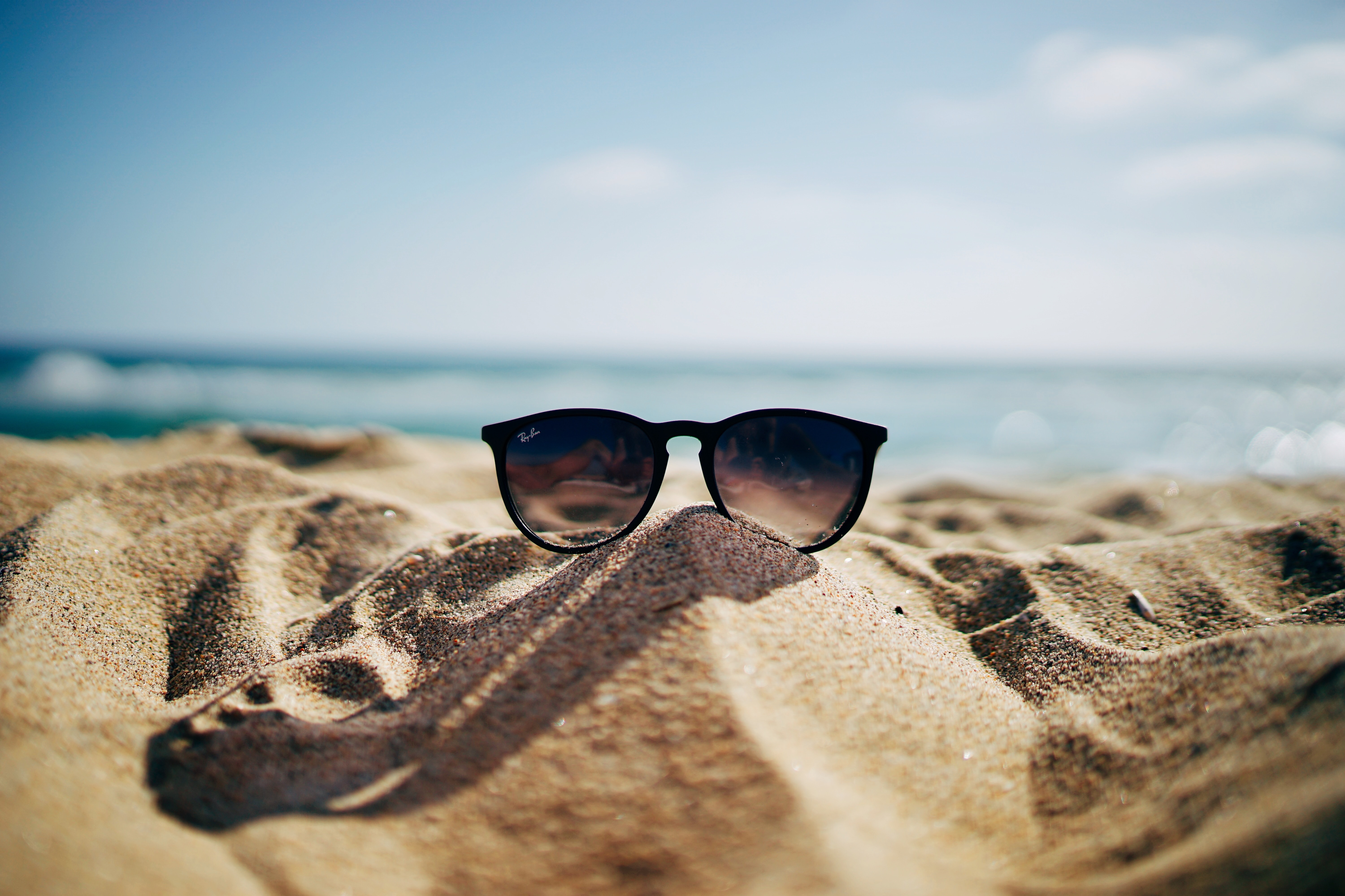 Sunglasses resting on a beach representing vacation